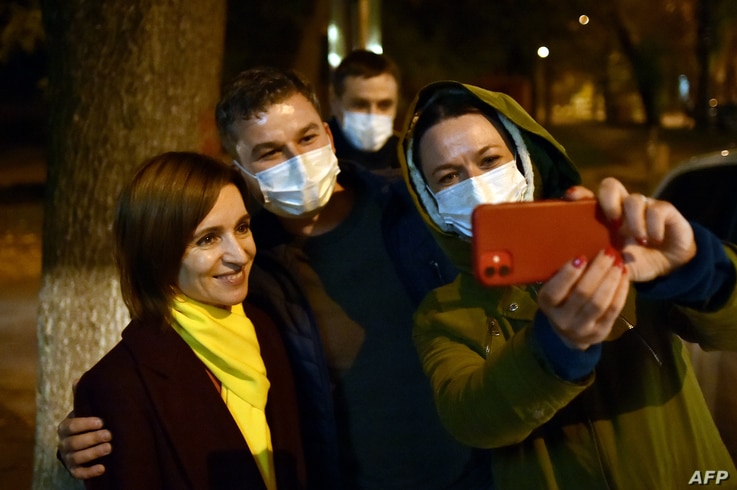 Moldova's presidential candidate Maia Sandu poses for a selfie photo with her supporters as she leaves the Action and…