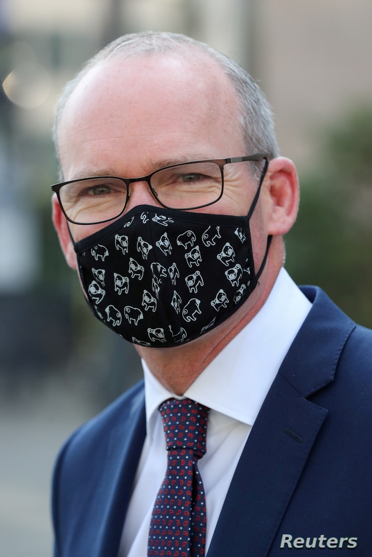 FILE PHOTO: Irish Foreign Minister Simon Coveney wearing a face mask, is seen after a European general affairs ministers…