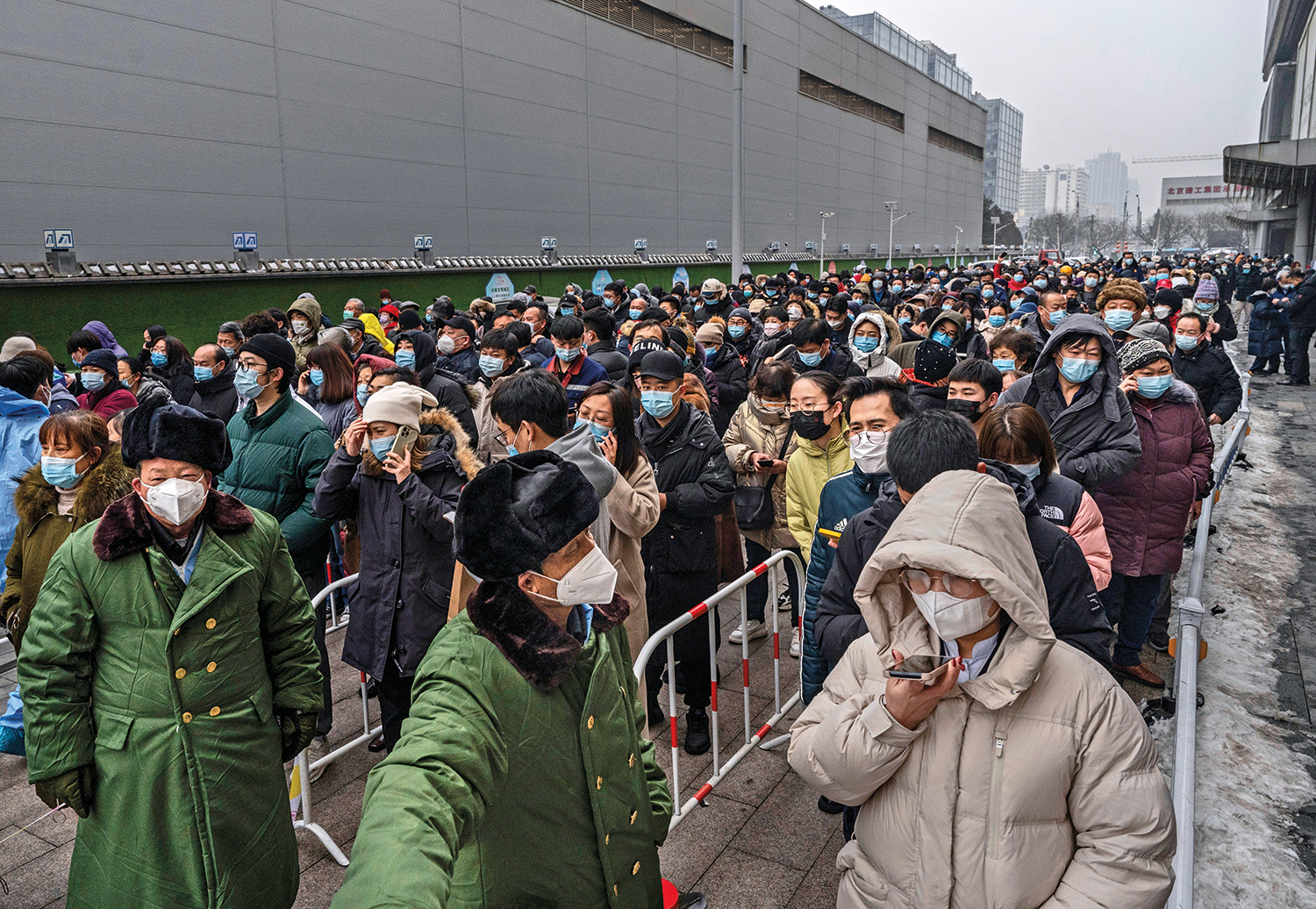 Security officers direct a line of people at a COVID-19 mass testing site in Beijing .