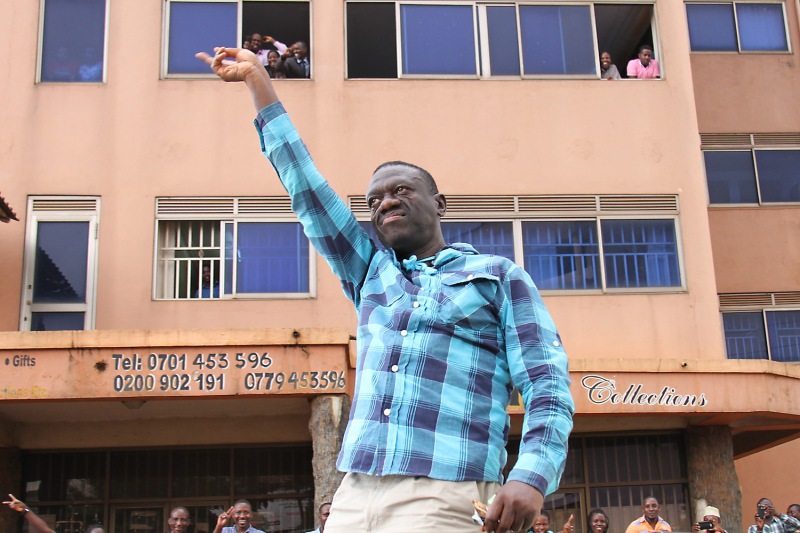 Ugandan opposition leader Kizza Besigye flashes his trademark “V sign” in the streets of Kampala, Uganda, on his way to a press conference on July 13, 2016.