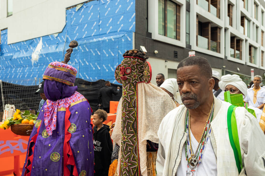 A performer in the Odunde procession walks towards the South Street Bridge for the offering.