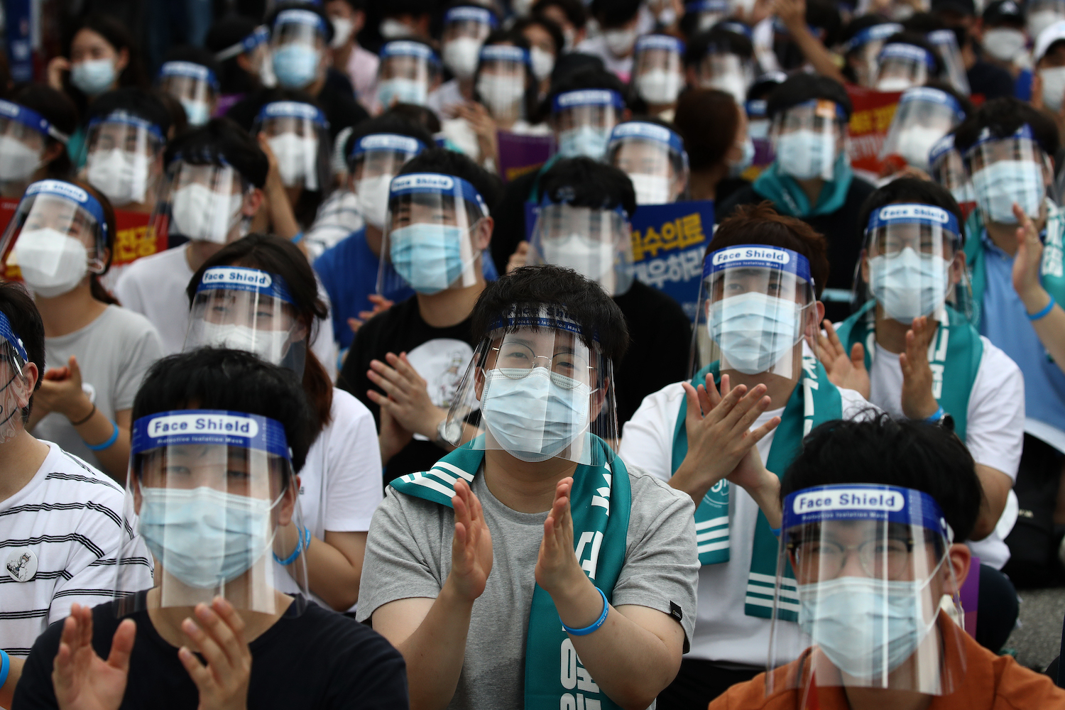 Doctors and medical students wearing protective equipment as a preventive measure against COVID-19 attend a rally against the government medical plan in Seoul on Aug. 14, 2020.